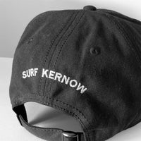 Back shot of our black organic Cotton Baseball Cap with embroidered 'Surf Kernow' text above the adjustable strap and buckle – designed and embroidered in Cornwall.